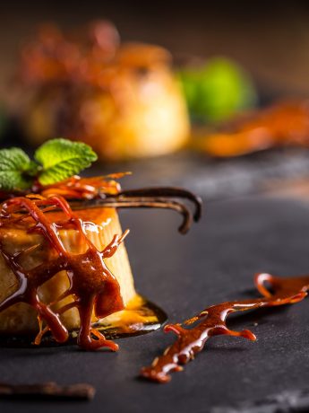 Flan aux oeufs – Recette facile et délicieuse de Flan de huevo 5 Flan aux oeufs sur ardoise avec caramel liquide, caramel dur, gousses de vanille et feuille de menthe.